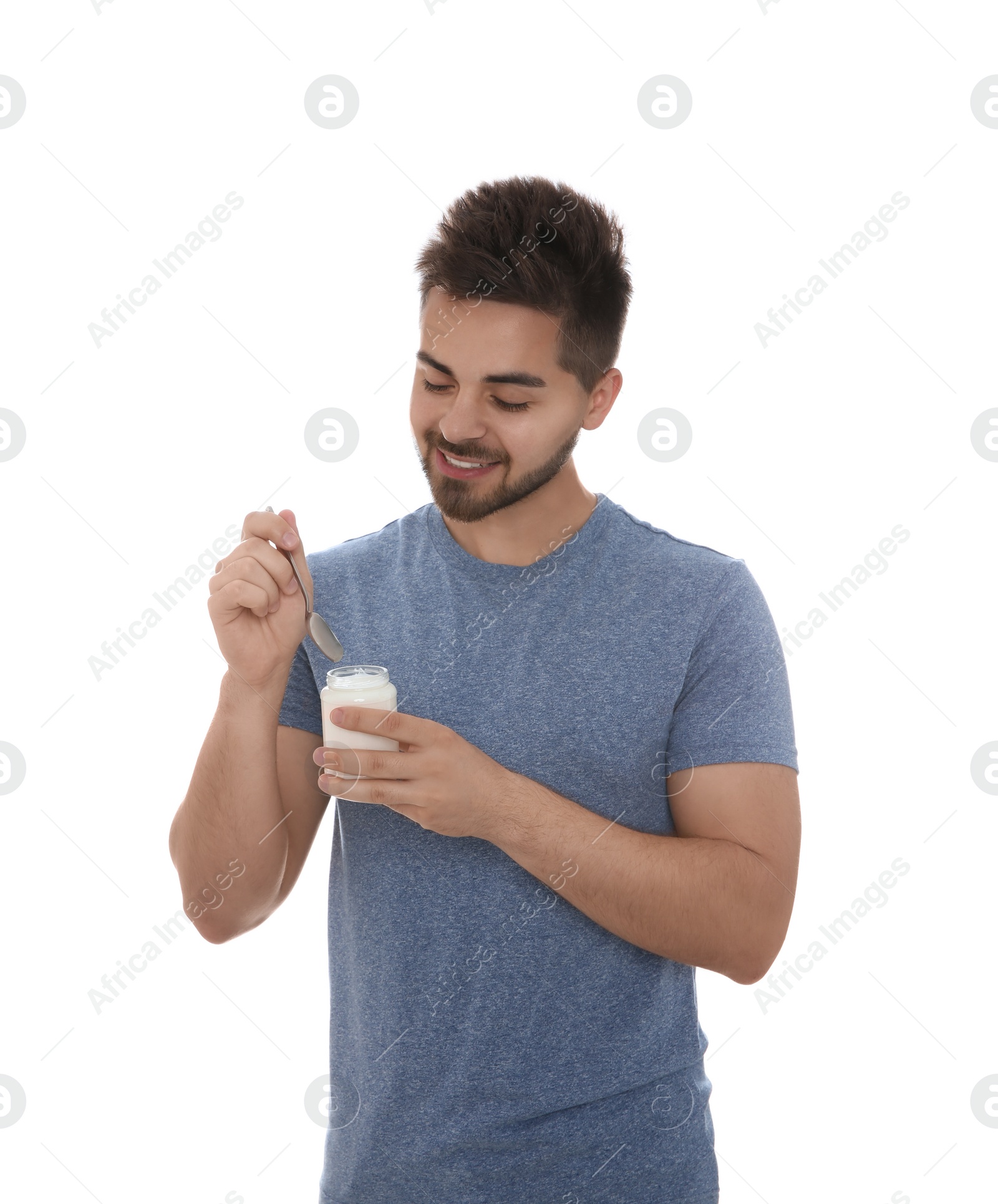 Photo of Happy young man with yogurt and spoon on white background