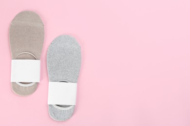 Photo of Soft cotton socks on light pink background, flat lay. Space for text
