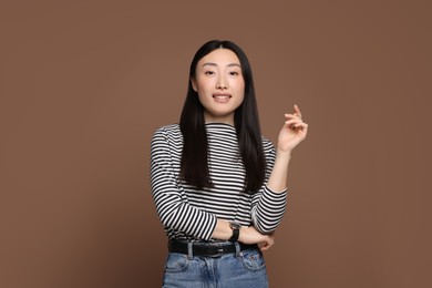 Photo of Portrait of smiling woman on brown background