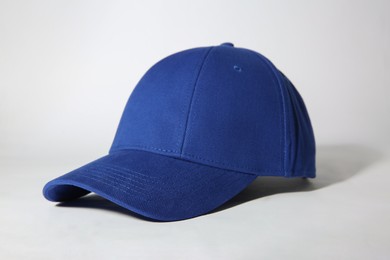 Photo of Stylish blue baseball cap on white background