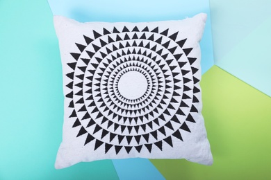 Soft decorative pillow on color background, top view