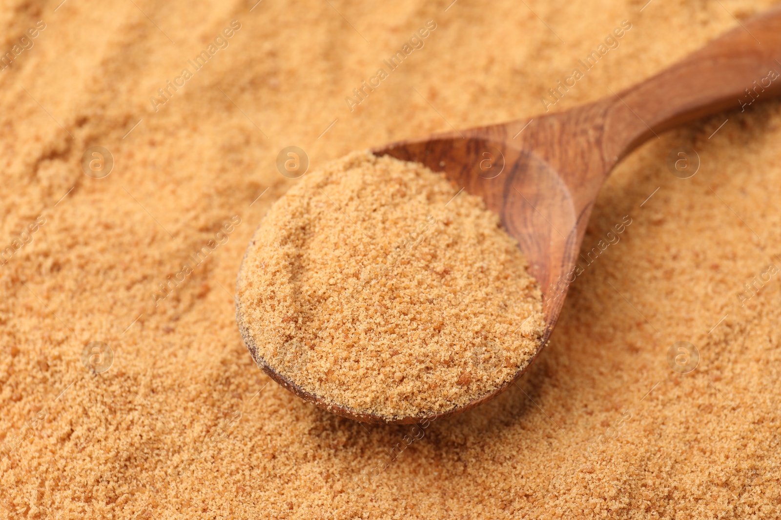 Photo of Brown coconut sugar and spoon, closeup view