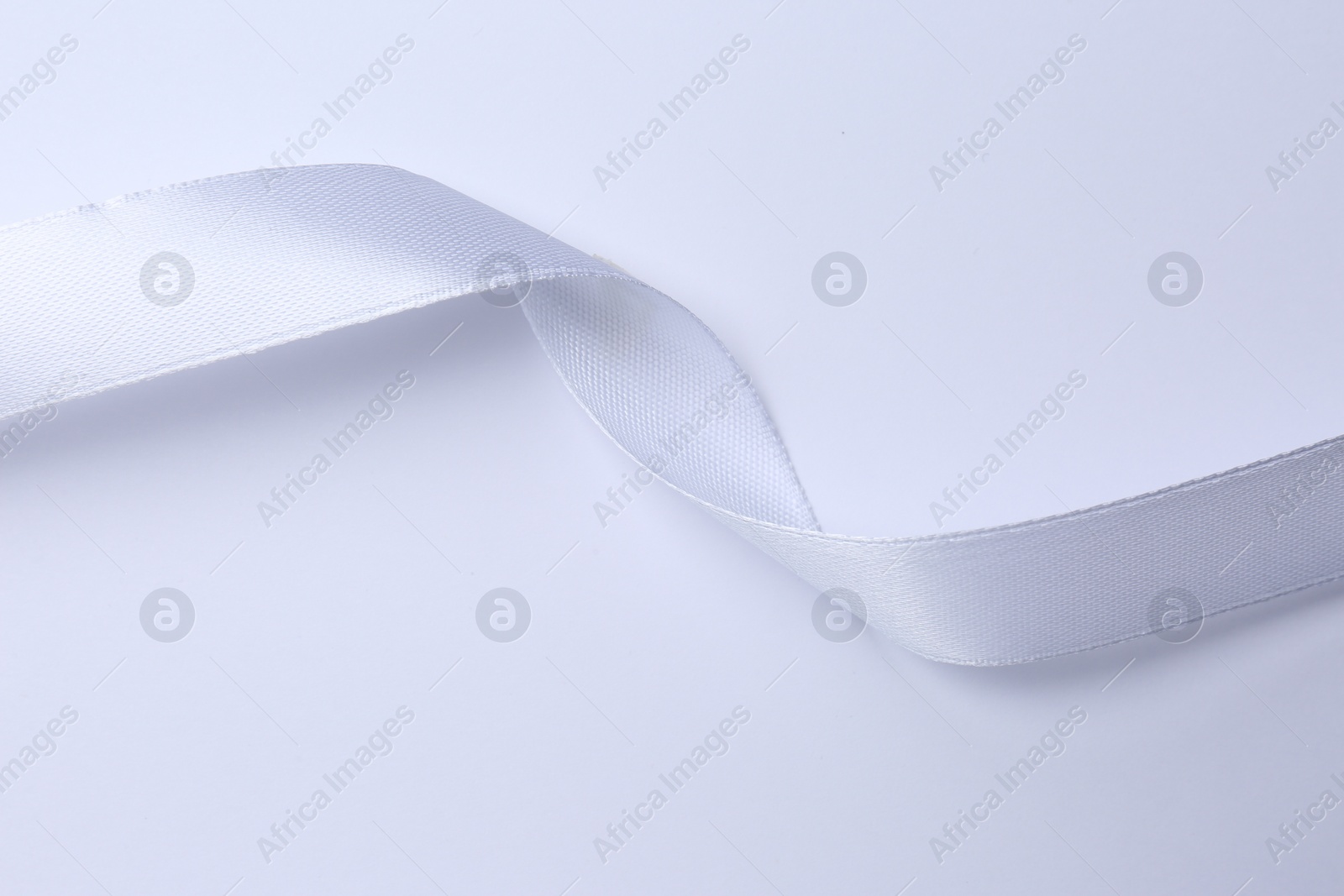 Photo of One beautiful silk ribbon on white background