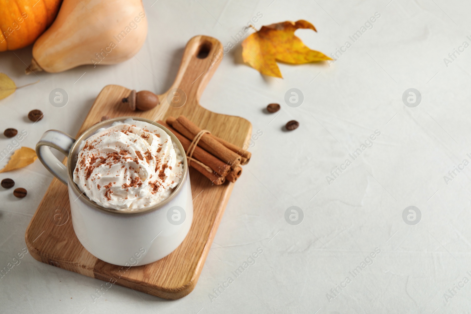 Photo of Cup with tasty pumpkin spice latte on light table, space for text