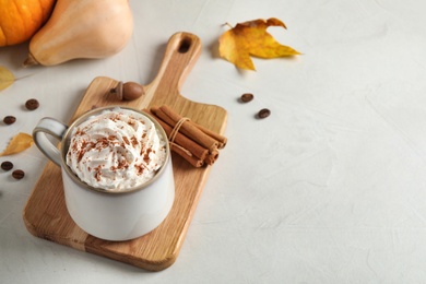 Photo of Cup with tasty pumpkin spice latte on light table, space for text
