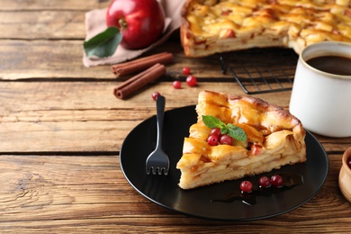 Photo of Slice of traditional apple pie with berries served on wooden table