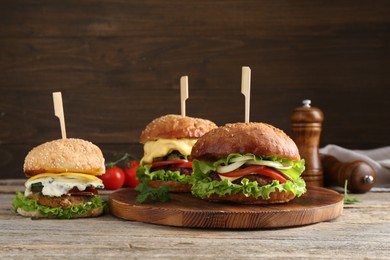 Photo of Delicious vegetarian burgers served on wooden table