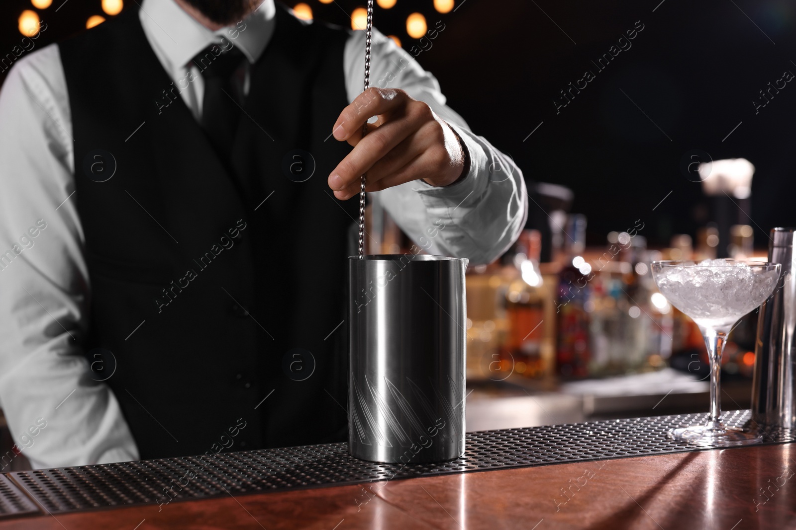 Photo of Bartender preparing fresh alcoholic cocktail at bar counter, closeup