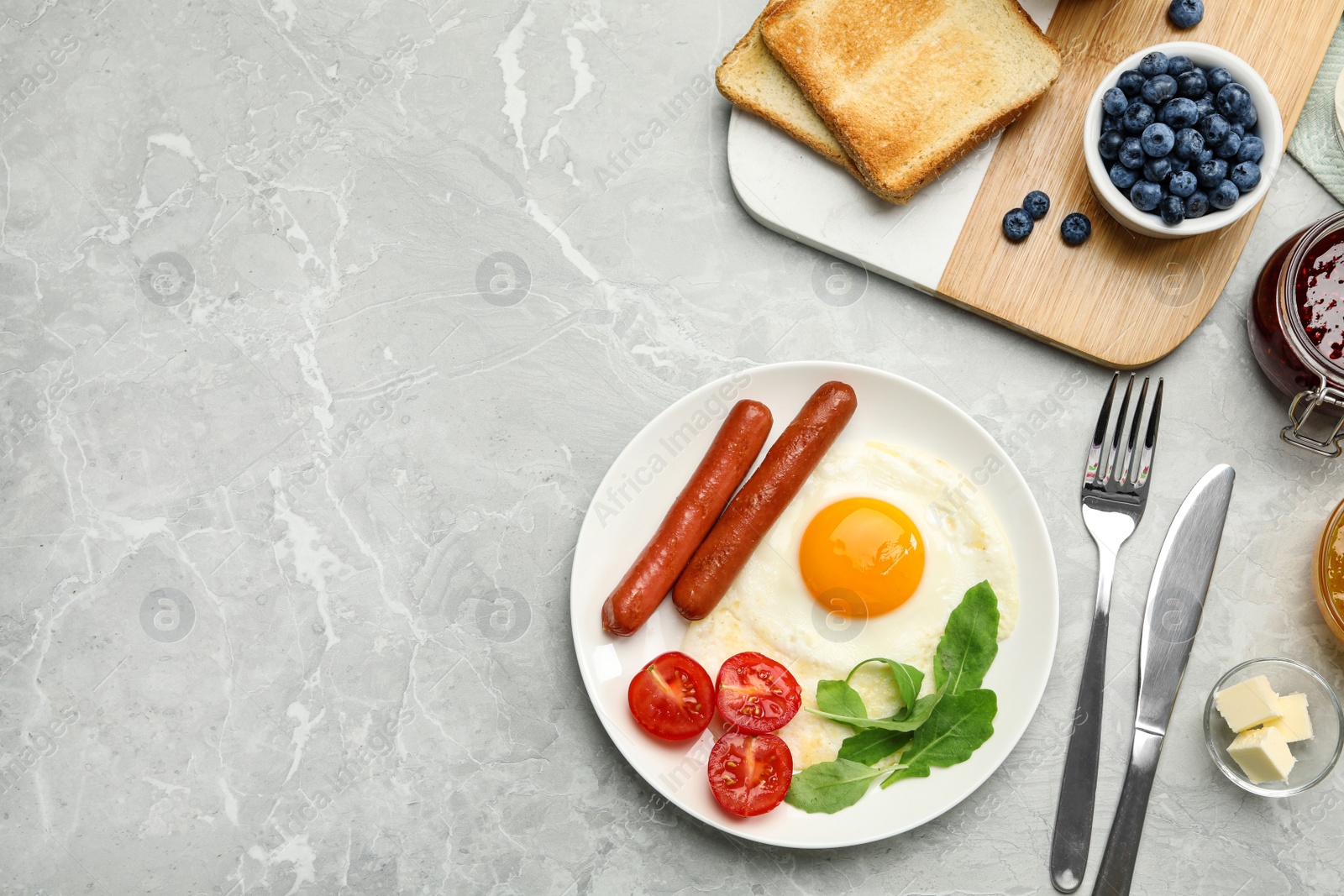Photo of Tasty breakfast with fried egg on light grey marble table, flat lay. Space for text