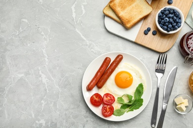 Photo of Tasty breakfast with fried egg on light grey marble table, flat lay. Space for text