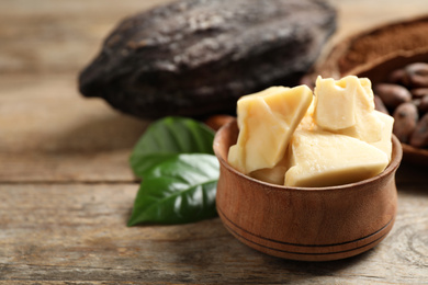 Organic cocoa butter on wooden table, closeup. Space for text