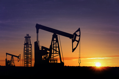 Image of Silhouettes of crude oil pumps at sunset