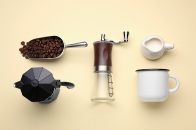 Photo of Flat lay composition with manual coffee grinder and beans on beige background