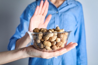 Woman refusing to eat peanuts, closeup. Food allergy concept