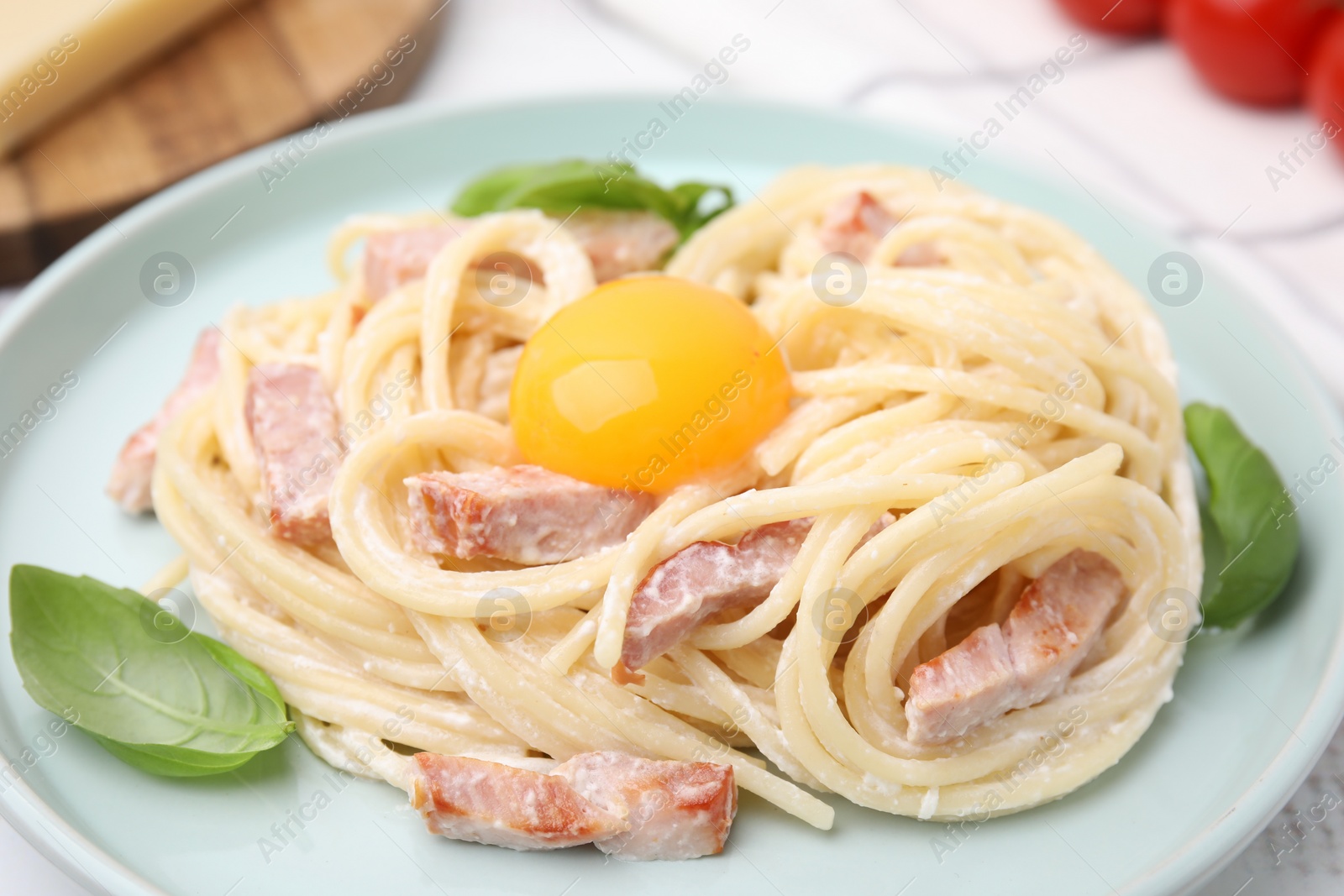 Photo of Delicious pasta Carbonara with egg yolk on table, closeup