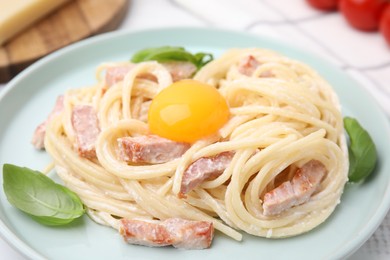 Delicious pasta Carbonara with egg yolk on table, closeup