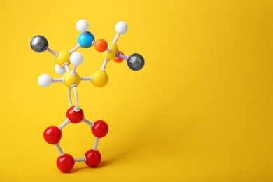 Structure of molecule on yellow background, space for text. Chemical model