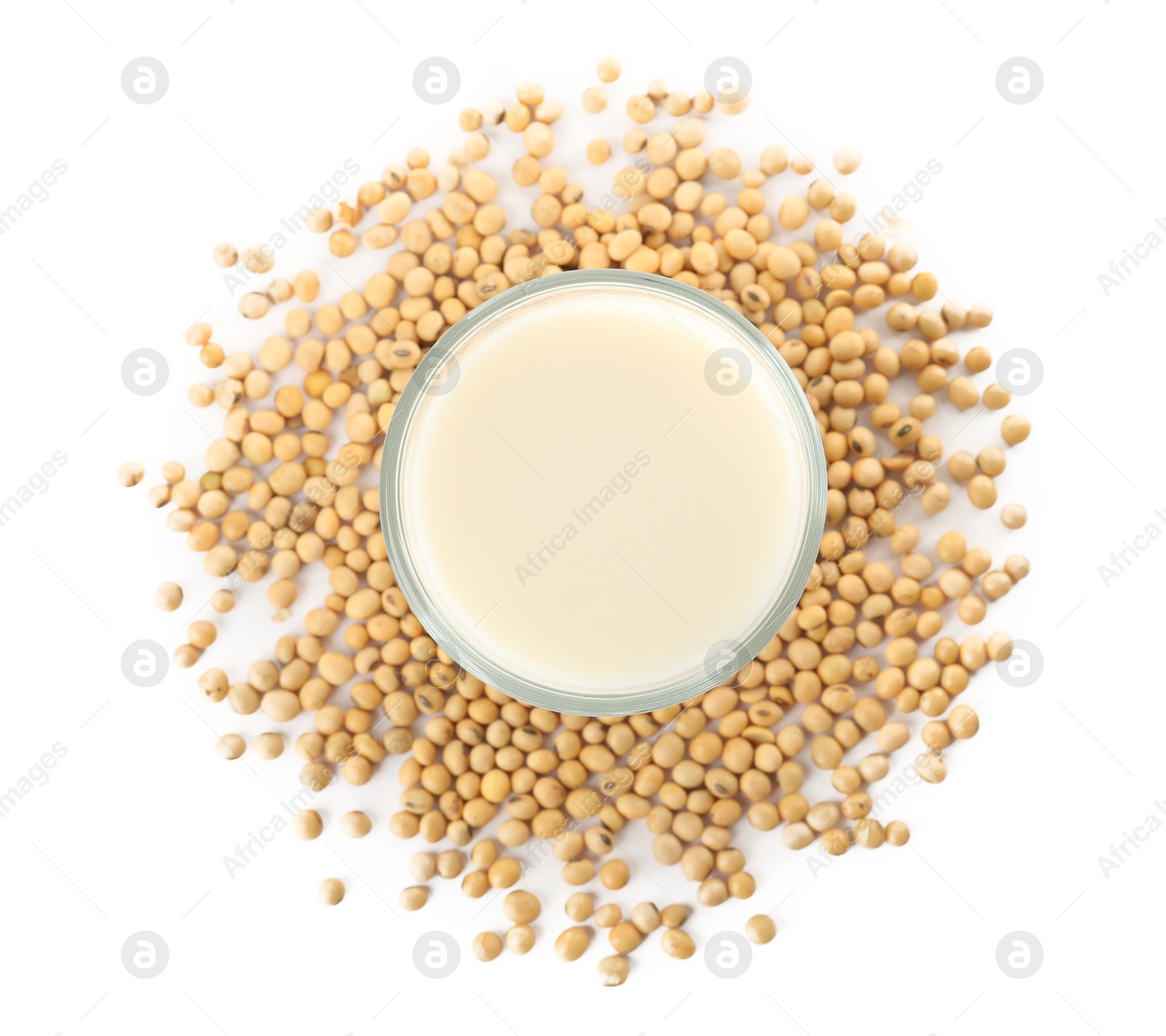 Photo of Glass of fresh soy milk and beans on white background, top view