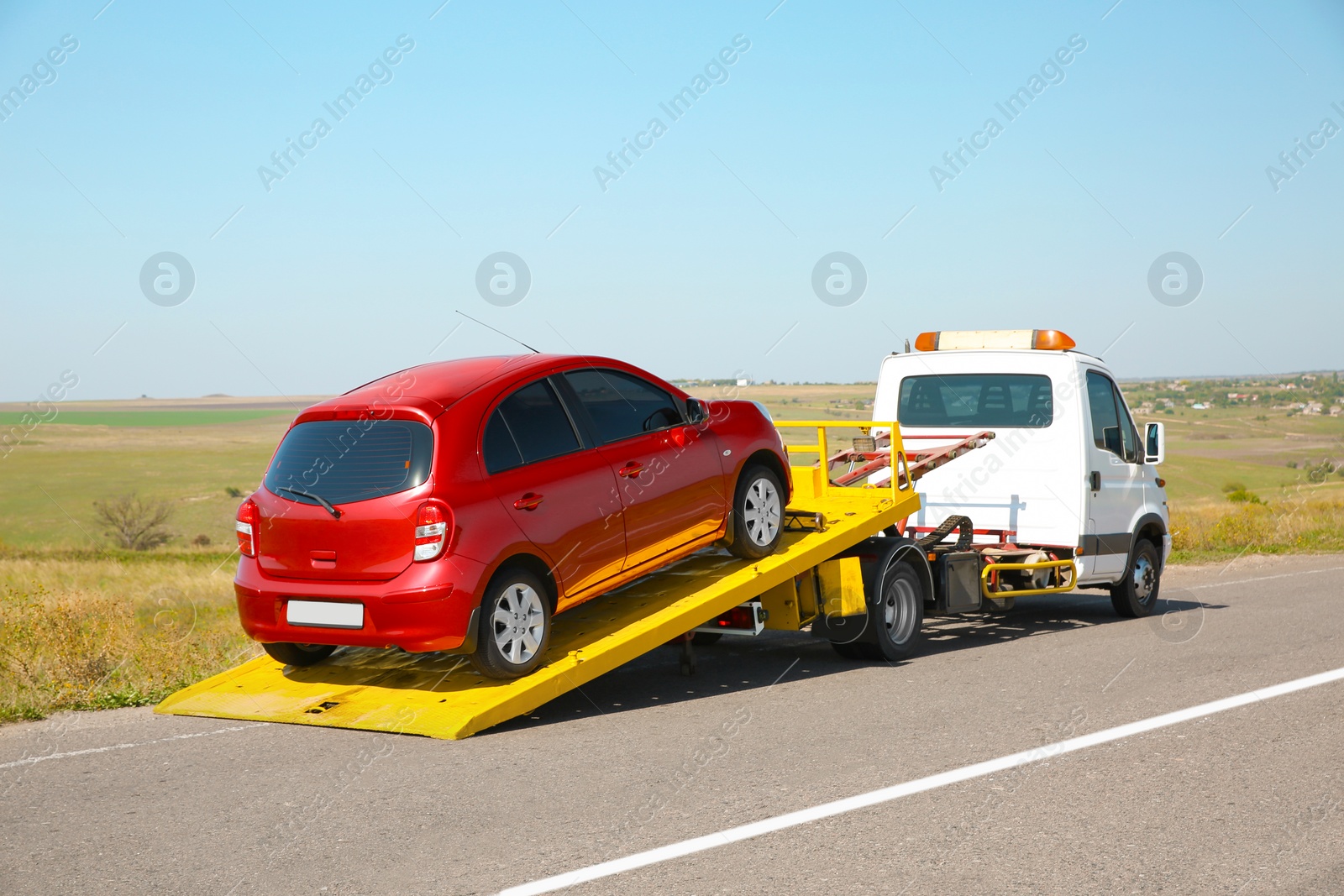 Photo of Tow truck with broken car on country road