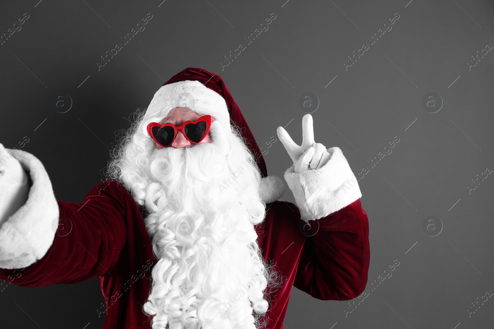 Photo of Authentic Santa Claus taking selfie on grey background