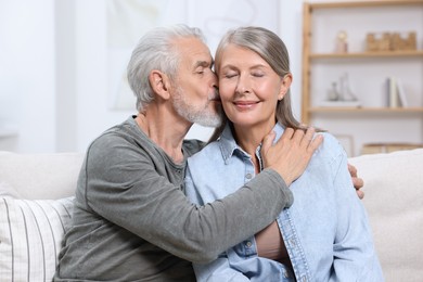 Photo of Senior man kissing his beloved woman at home