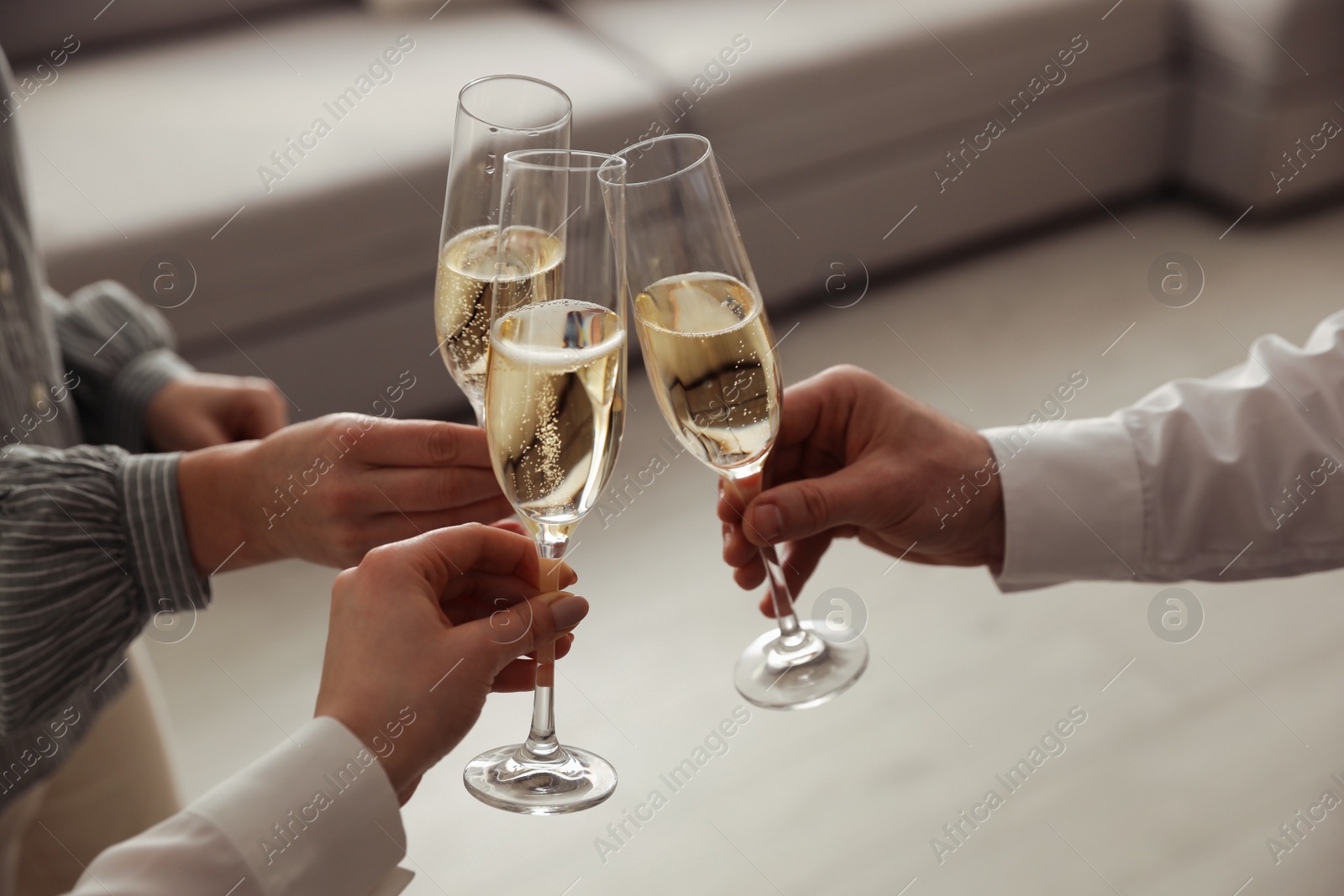 Photo of People clinking glasses with champagne at home, closeup