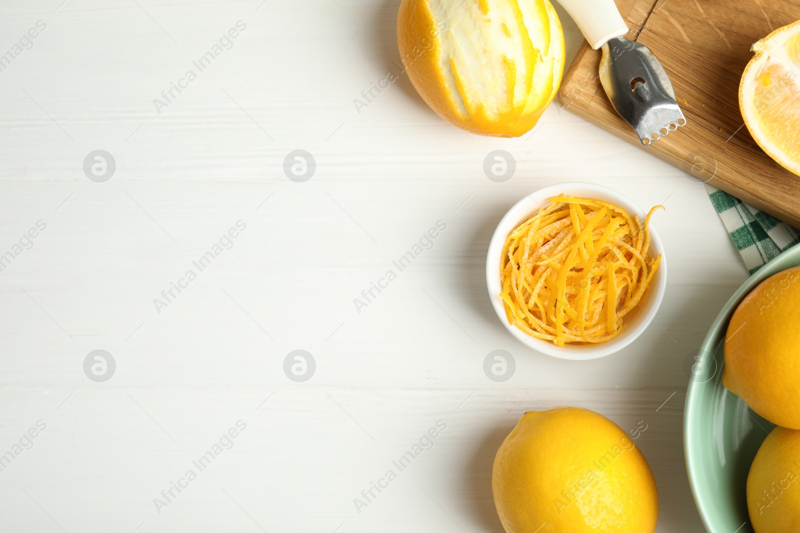 Photo of Lemon zest and fresh fruits on white wooden table, flat lay. Space for text