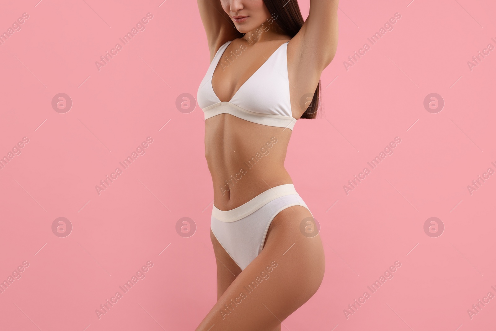 Photo of Young woman in stylish white bikini on pink background, closeup
