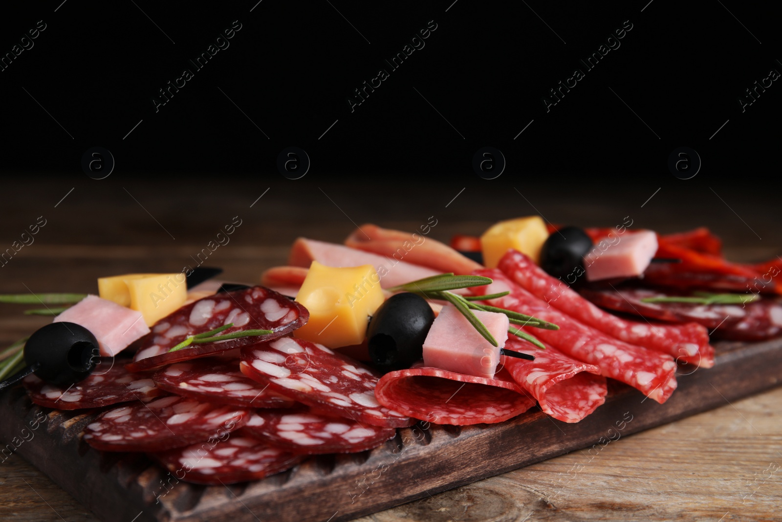 Photo of Tasty ham with other delicacies served on wooden table, closeup