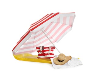 Photo of Open striped beach umbrella, inflatable mattress, bag and accessories on white background