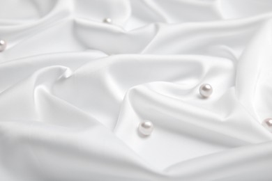 Photo of Many beautiful pearls on delicate white silk