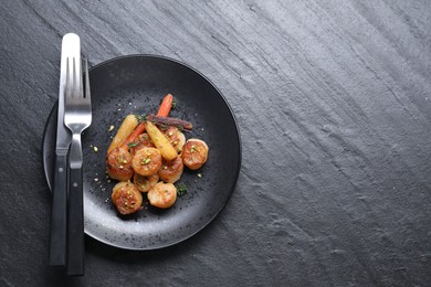 Photo of Delicious fried scallops served on dark gray textured table, top view. Space for text