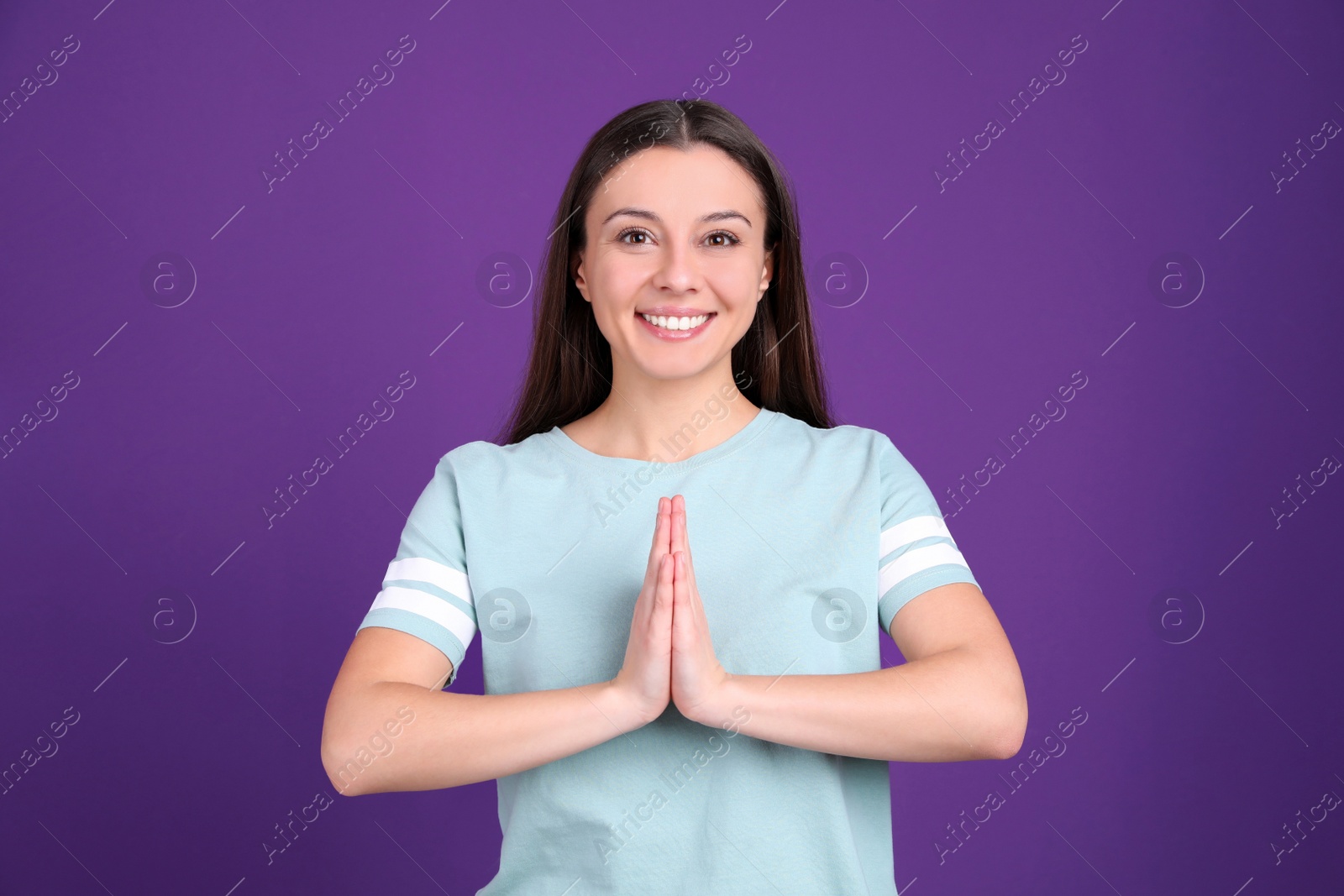 Photo of Young woman meditating on purple background. Stress relief exercise