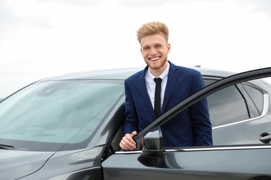 Photo of Young successful man near modern car outdoors