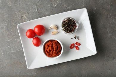 Photo of Red curry paste and ingredients on grey table, top view