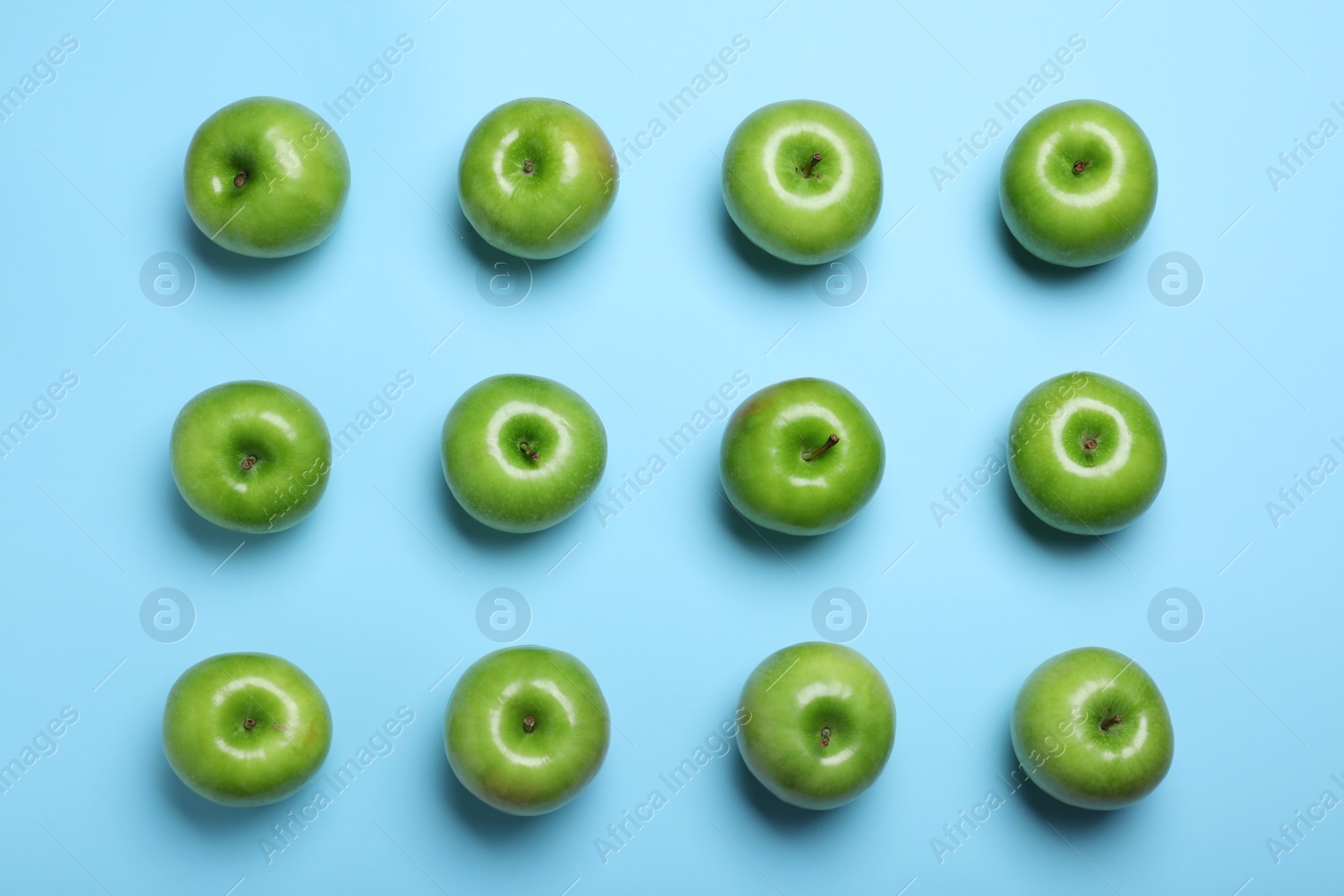 Photo of Tasty green apples on light blue background, flat lay