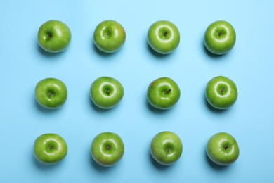 Tasty green apples on light blue background, flat lay