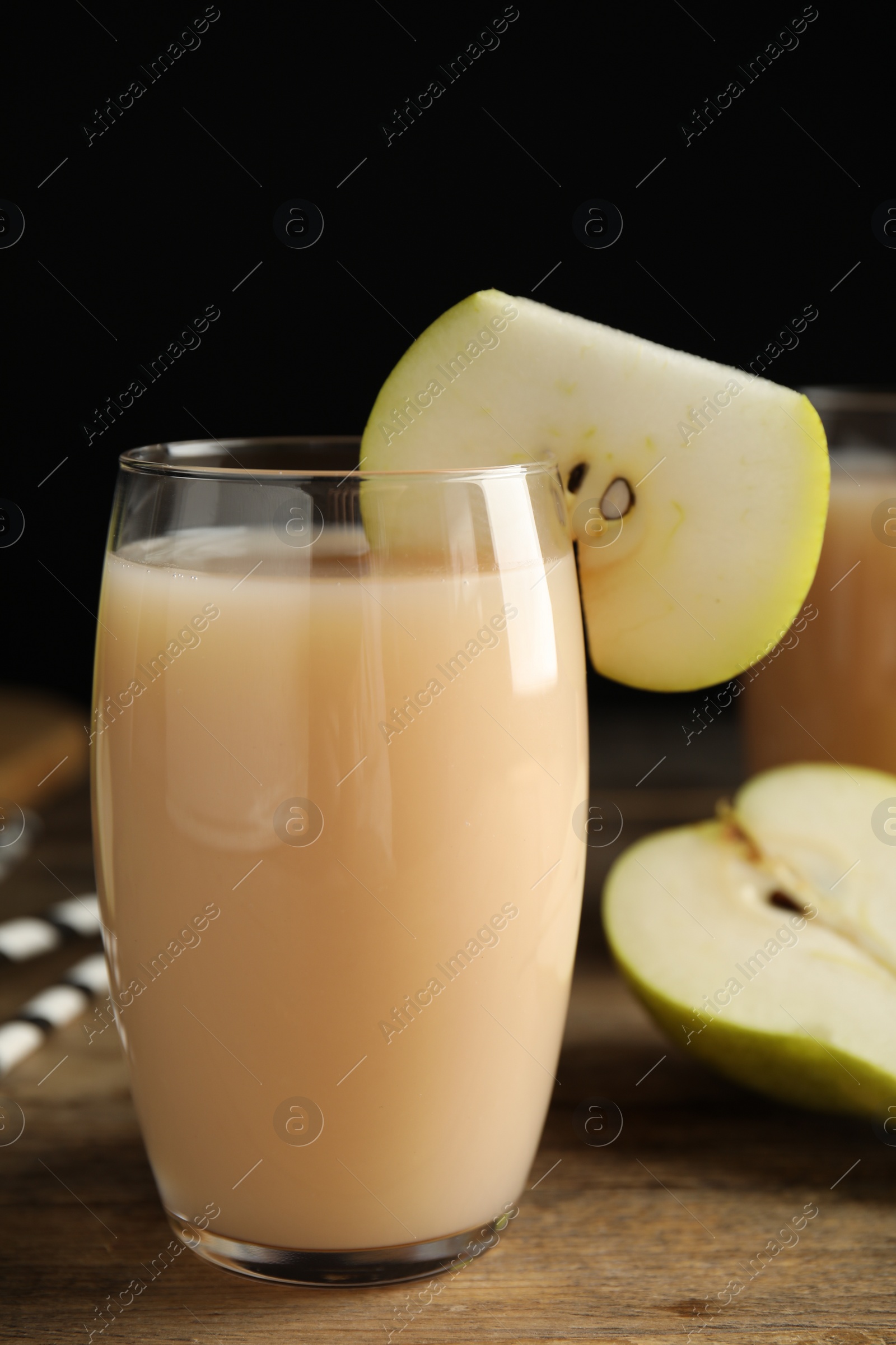 Photo of Fresh pear juice in glass and fruit on wooden table, closeup