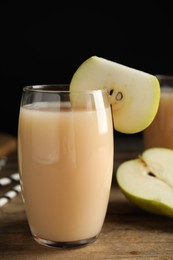 Fresh pear juice in glass and fruit on wooden table, closeup