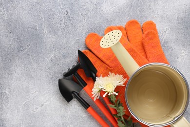 Photo of Watering can, gardening tools and beautiful flower on light grey background, flat lay. Space for text