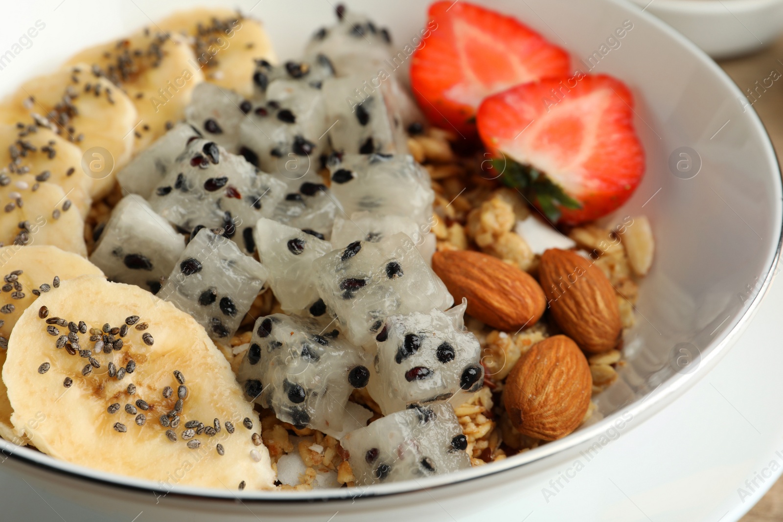 Photo of Granola with pitahaya, banana and strawberry in bowl, closeup