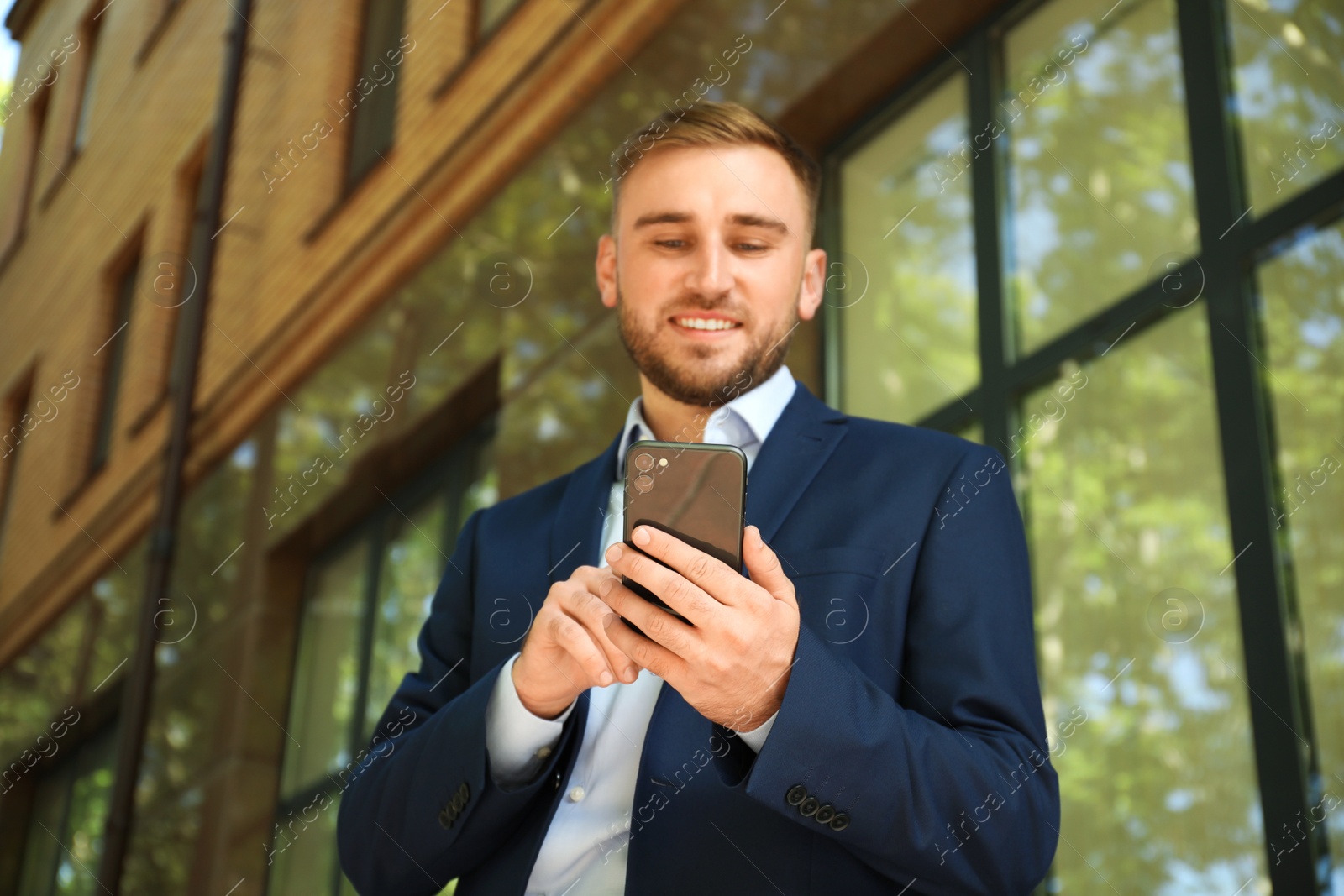 Photo of Young man using smartphone on city street