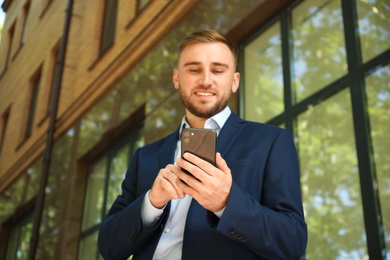 Young man using smartphone on city street