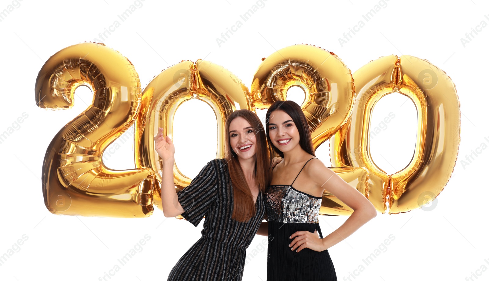 Photo of Happy young women near golden 2020 balloons on white background. New Year celebration