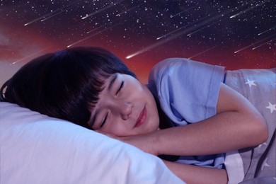 Image of Cute little boy sleeping in bed and beautiful starry sky at night on background