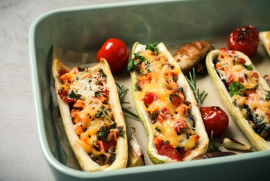 Photo of Delicious stuffed zucchini in baking dish on light grey table