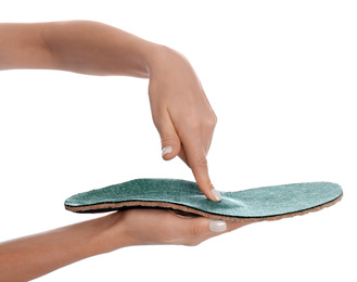Woman showing orthopedic insole on white background, closeup