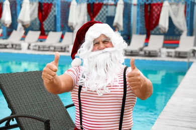 Photo of Authentic Santa Claus near swimming pool at resort