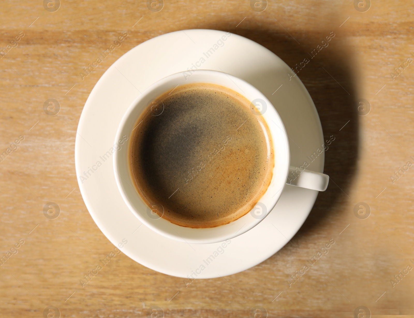 Photo of Cup of delicious hot coffee on wooden background, top view