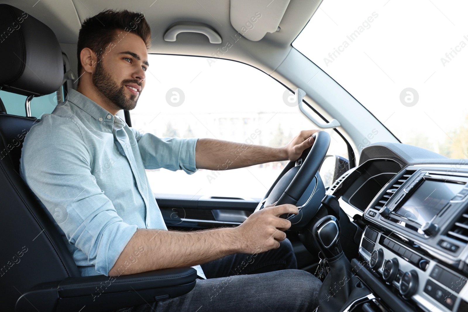 Photo of Handsome young man driving his modern car